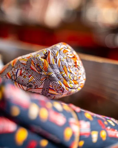 Gerollte Stoffe mit afrikanischen Mustern in Orange und Rot