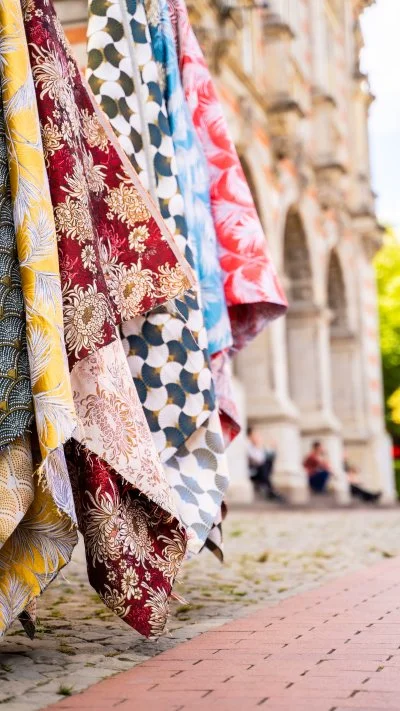 Gemusterte Stoffe vor historischem Altstadtgebäude